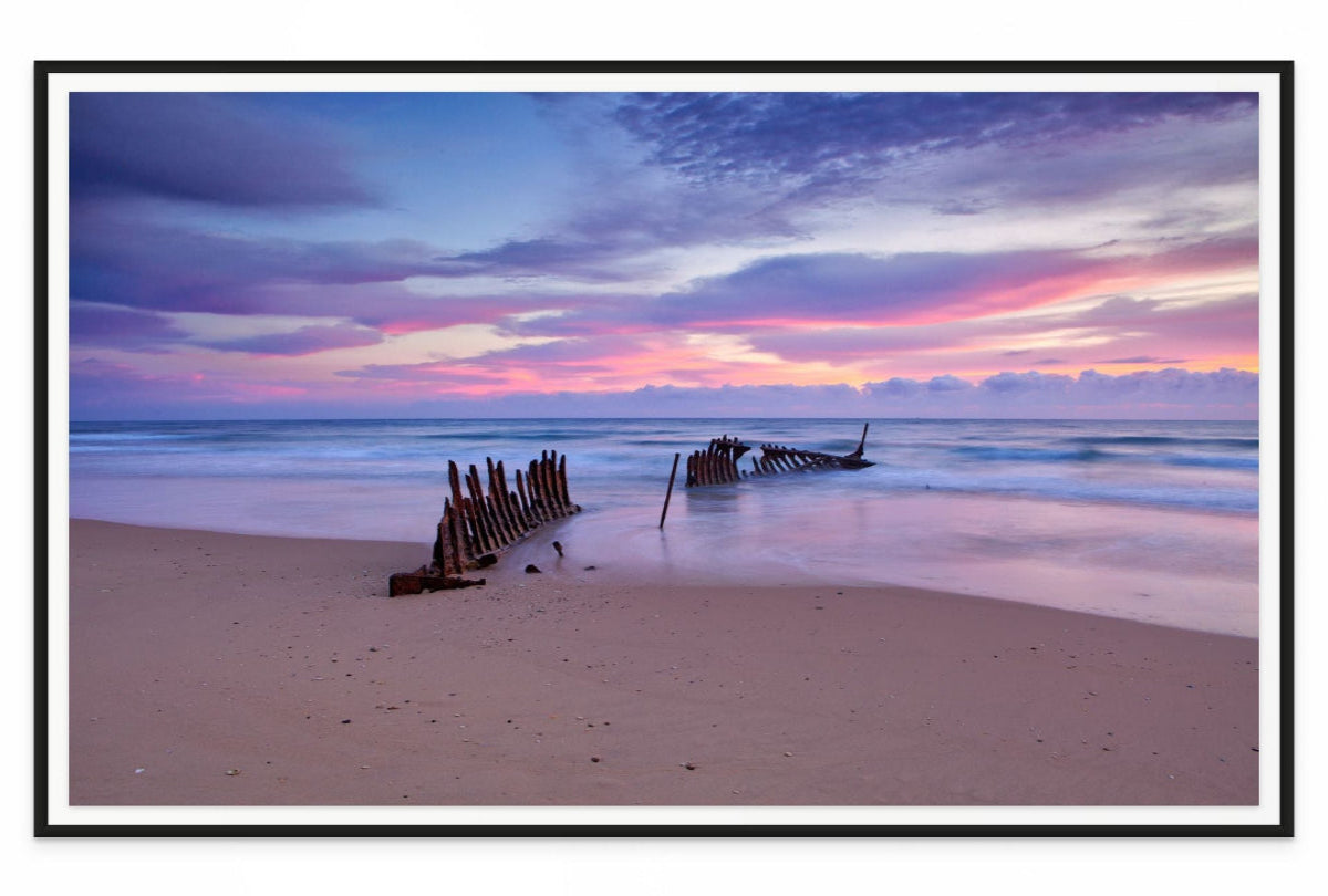 Wreck on dicky  beach with a colorful sunset sky. Black framed wall art print