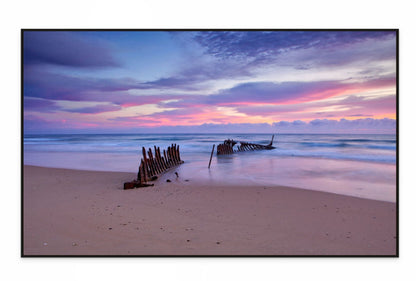 Canvas print dicky Beach scene with a shipwreck at sunset, featuring a colorful sky.