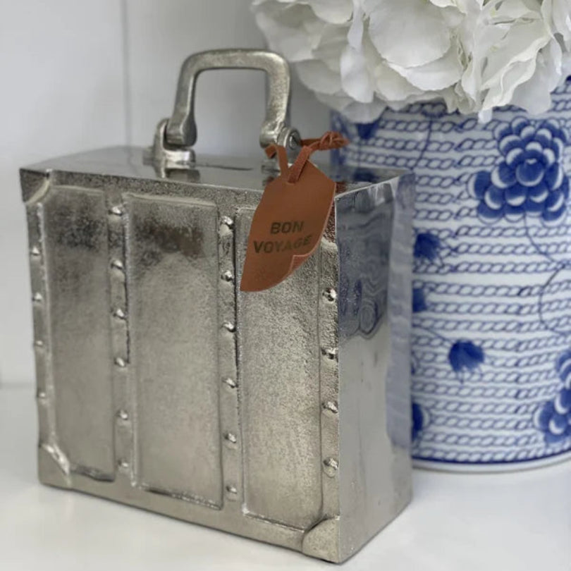 Silver suitcase money bank with Bon Voyage tag styled with blue and white Hamptons vase