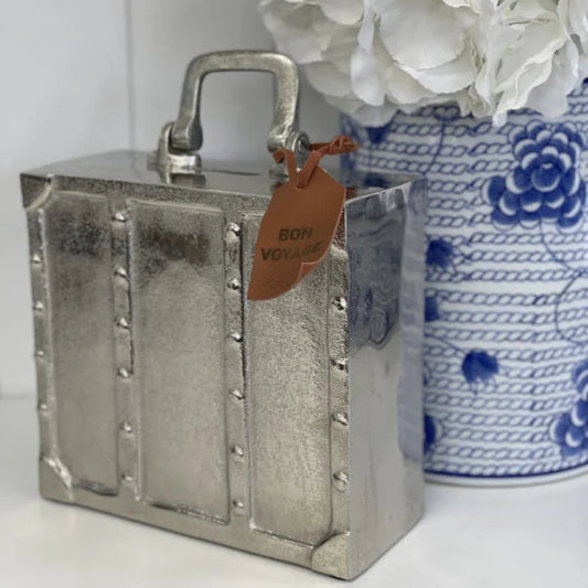 Silver suitcase money bank with Bon Voyage tag styled with blue and white Hamptons vase