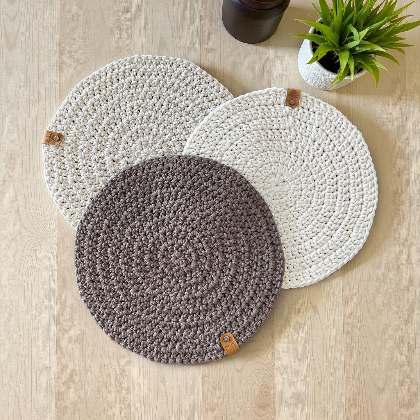 Handmade round crochet placemats in natural, beige and brown.