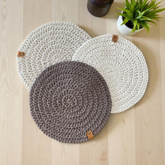 Handmade round crochet placemats in natural, beige and brown.