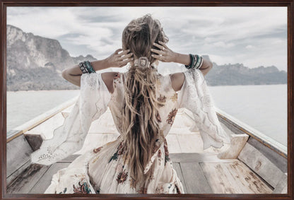 Wall art print of boho lady with long hair sitting on a boat with mountains in the background