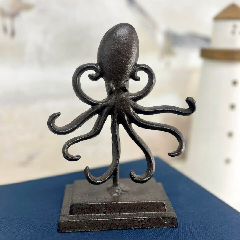 Decorative black metal octopus sculpture on a stand